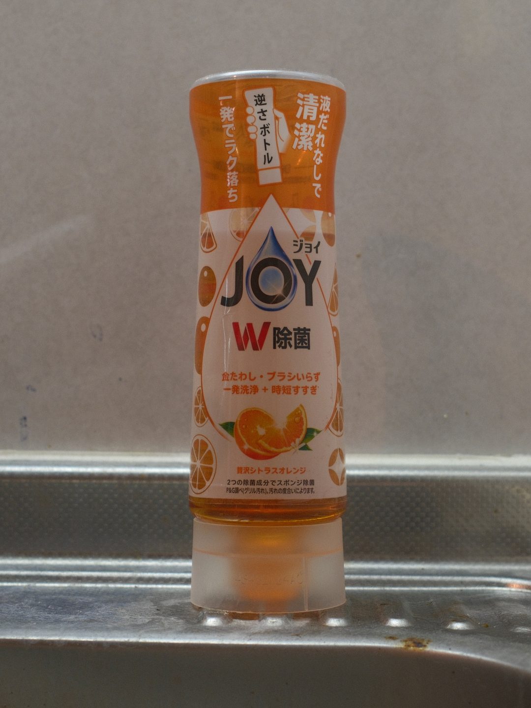 台所のシンクに置いてあるジョイW除菌 贅沢シトラスオレンジの逆さボトル